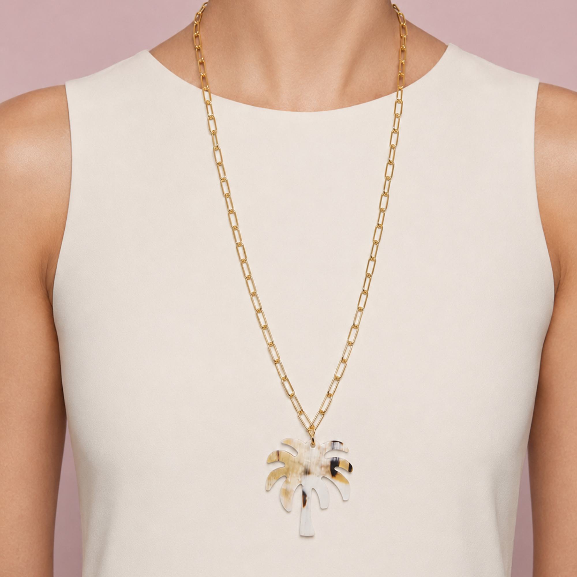 MLO palm pendant necklace styled over a clean ivory top