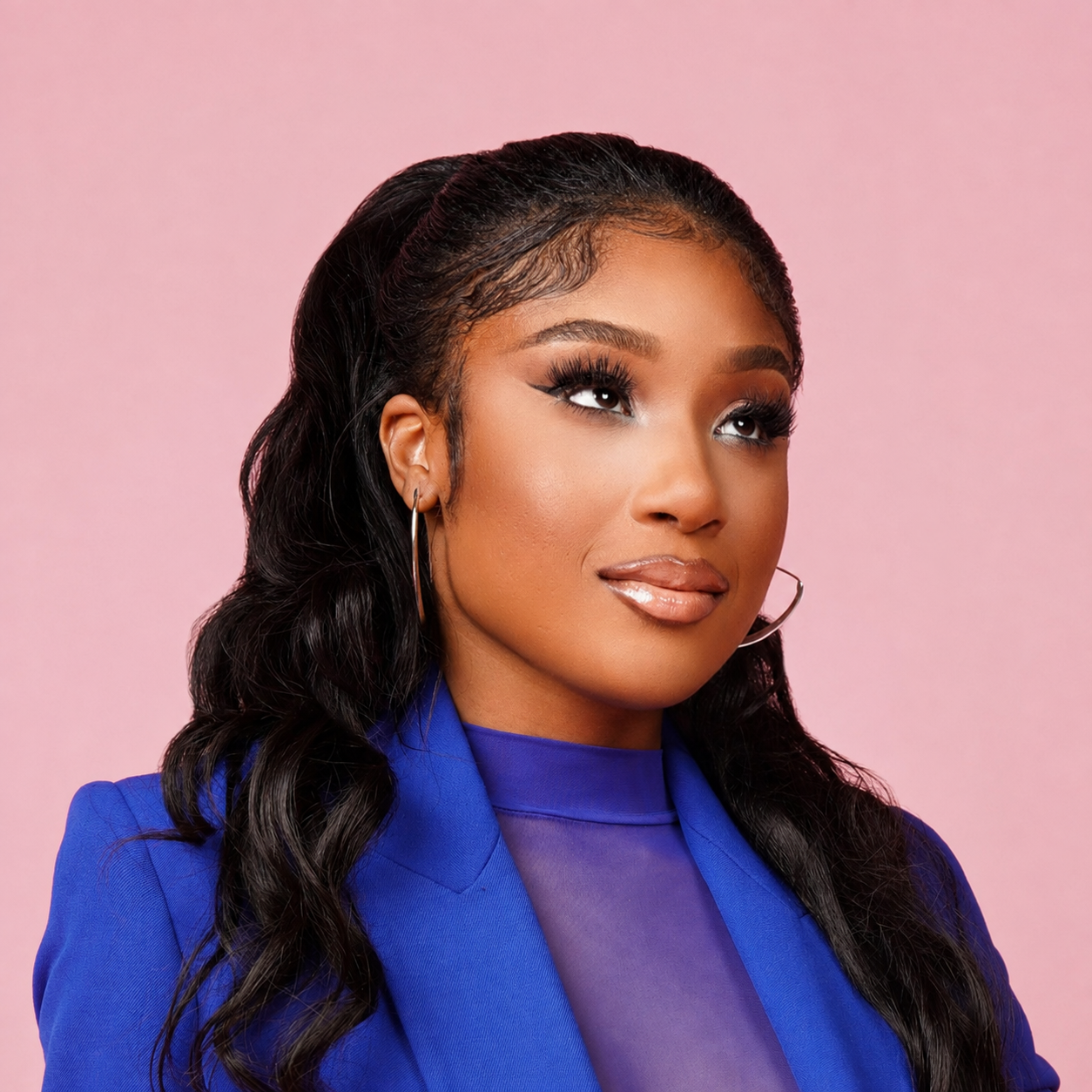 Ti Taylor in a cobalt blue blazer against a blush pink backdrop